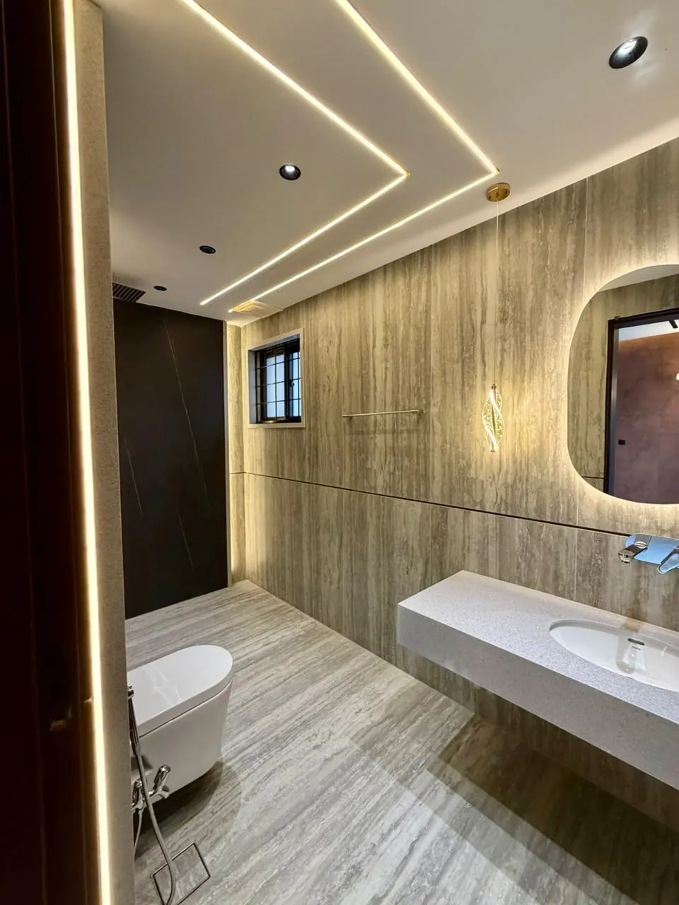 Bathroom with freestanding bathtub and backlit mirror