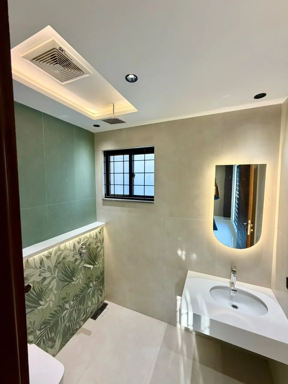Guest bathroom with backlit mirror